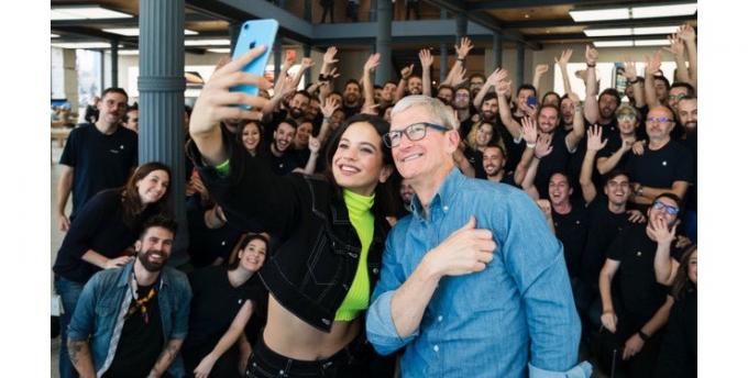 Apple'ın CEO'su ve İspanyol şarkıcı Rosalía, Madrid Apple çalışanları ile bir selfie çekiyor.