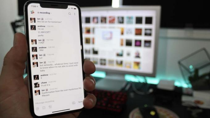 Slack aplikace pro iOS na iPhone před počítačem