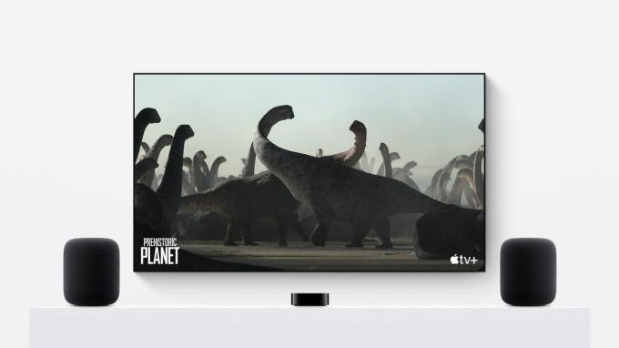 HomePods druge generacije v stereo paru z Apple TV 4K in ogromnim TV-zaslonom, ki prikazuje dokumentarni film Apple TV+ o dinozavrih 