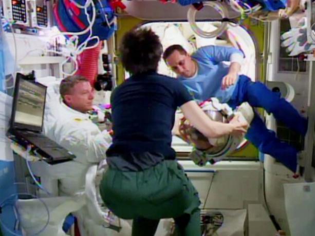 テリー・バーツ、左、サマンサ・クリストフォレッティとアントン・シュカプレロフは、バーツのヘルメットに少量の水を発見した後、ヘルメットを調べます。 写真：NASA TV