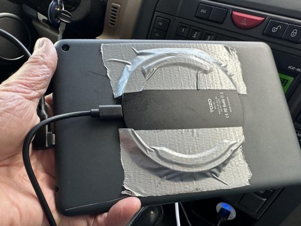 Amazon Fire タブレットの背面にダクトタップで接続された Qi 充電器