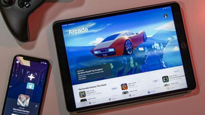 „iPad“, naršantis „Apple Arcade“ žaidimų kataloge su „iPhone“ ir „Xbox“ valdikliu