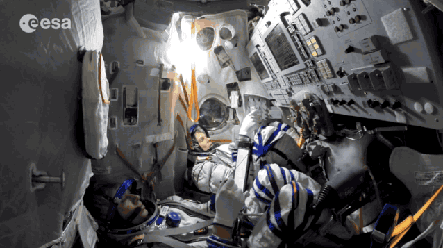 ESA-astronaut Andreas Mogensen, links, en de Russische kosmonaut Sergei Volkov werken door middel van kunstmatig vuur aan boord van een Sojoez-simulator.