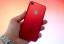 (PRODUKTAS) RAUDONA „iPhone 7“ išpakavimas: rankos su raudonu „iPhone“