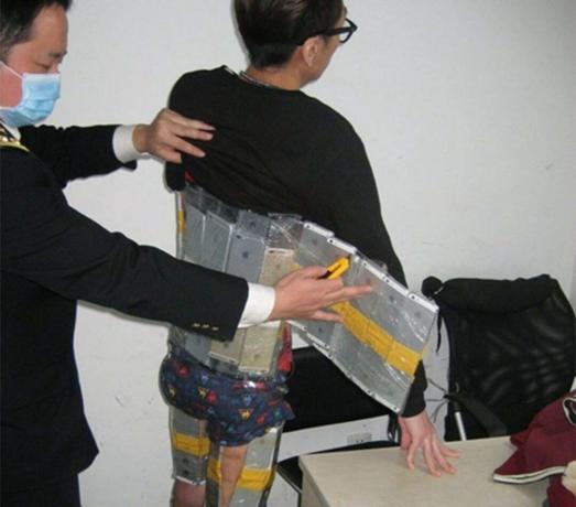 Urzędnicy celni w Chinach przyłapali tego człowieka na próbie przemytu 94 iPhone'ów do kraju. Zdjęcie: Sina News