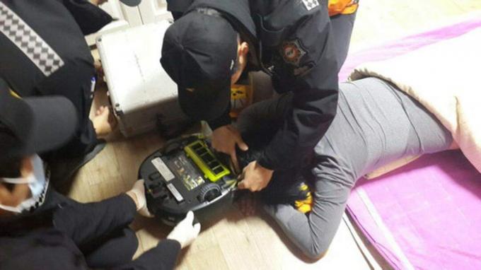 Ensihoitajat pyrkivät vapauttamaan naisen robotti -tyhjiön otteista. Kuva: Changwonin palokunta